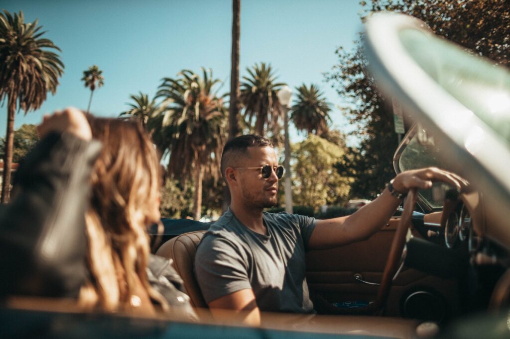 man and woman riding convertible car