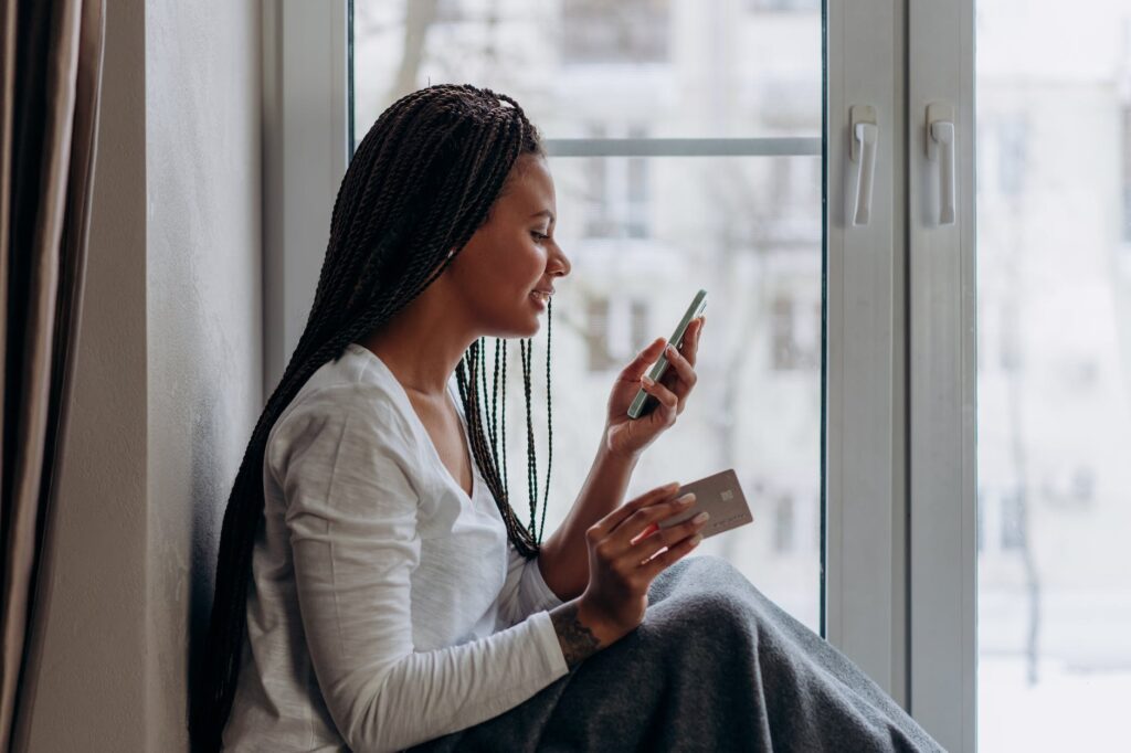 a woman talking on the phone holding a credit card