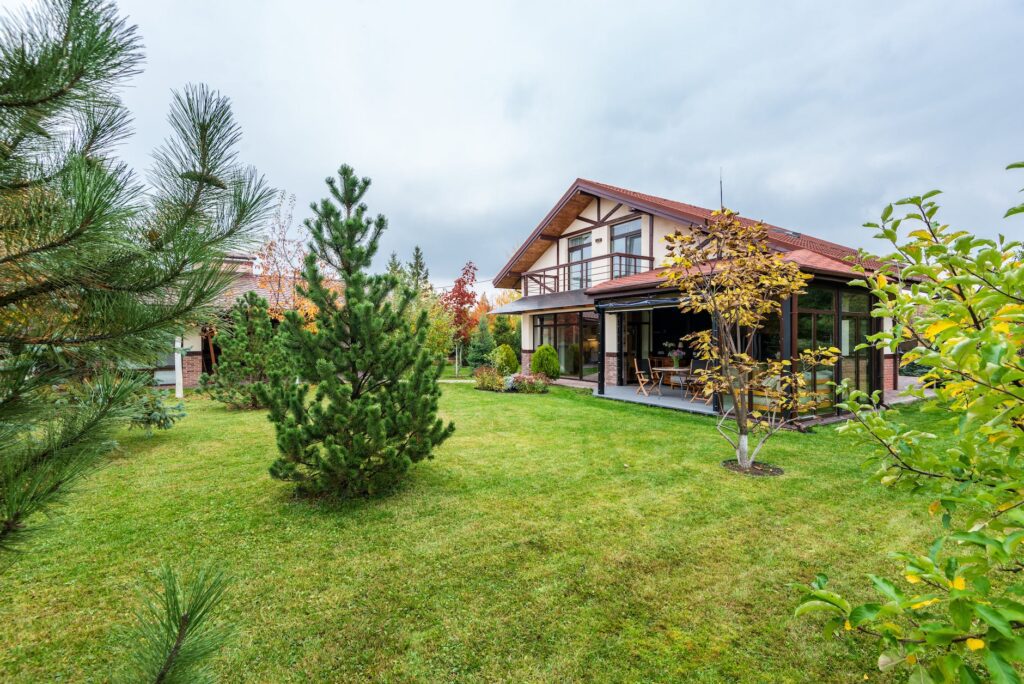 cottage with veranda and trees growing in backyard