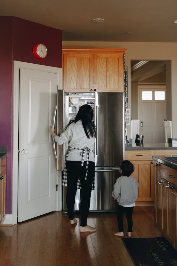 mother and child standing infront of an open refrigerator