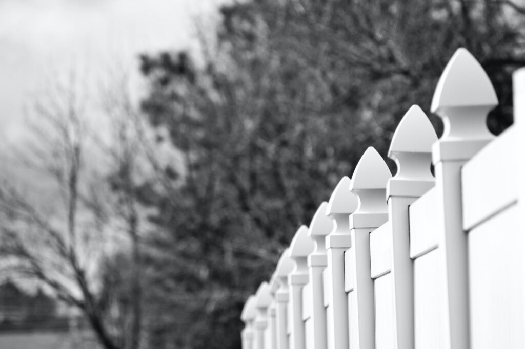 gray scale photo of white fence