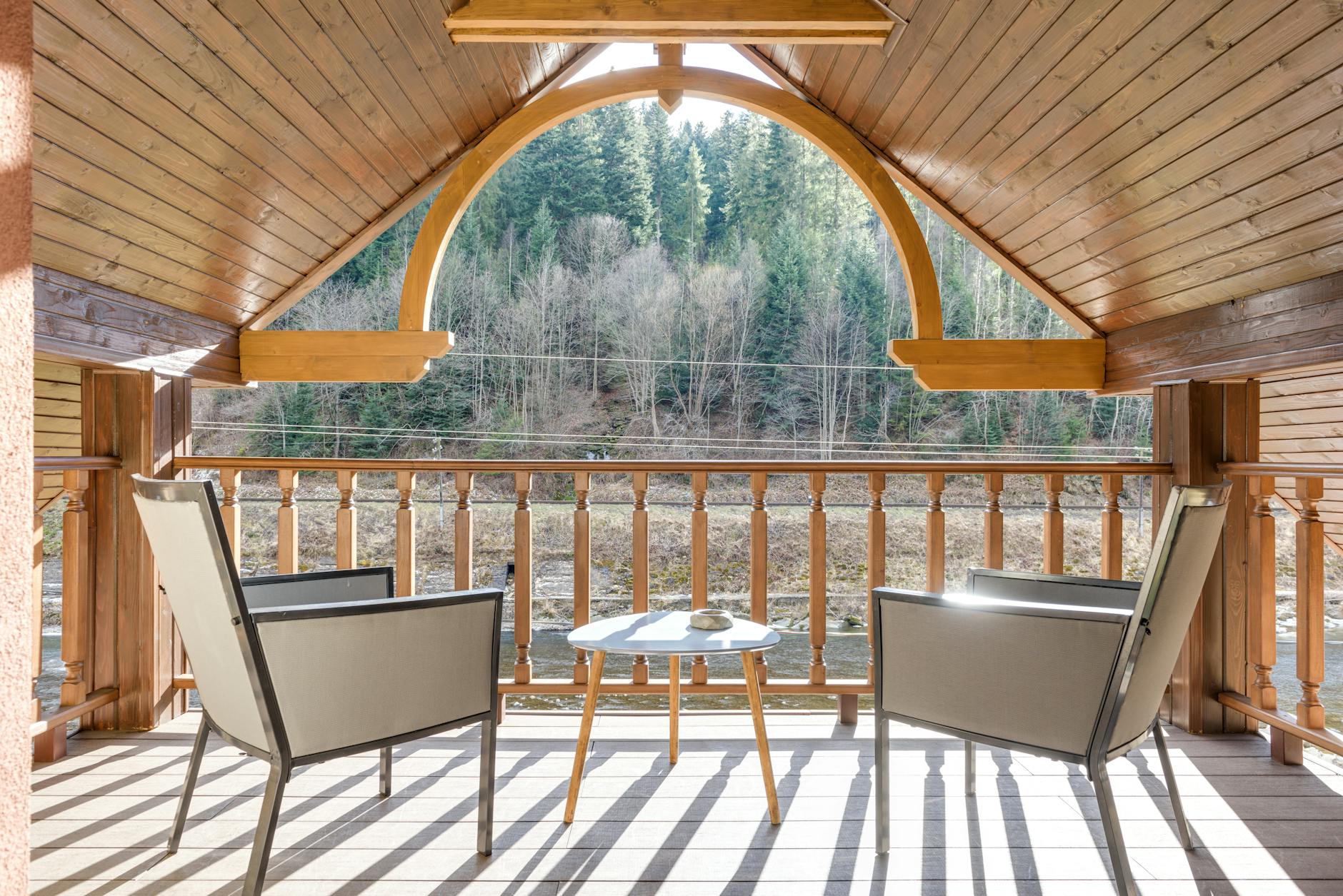 wooden balcony on attic with steel framed chairs